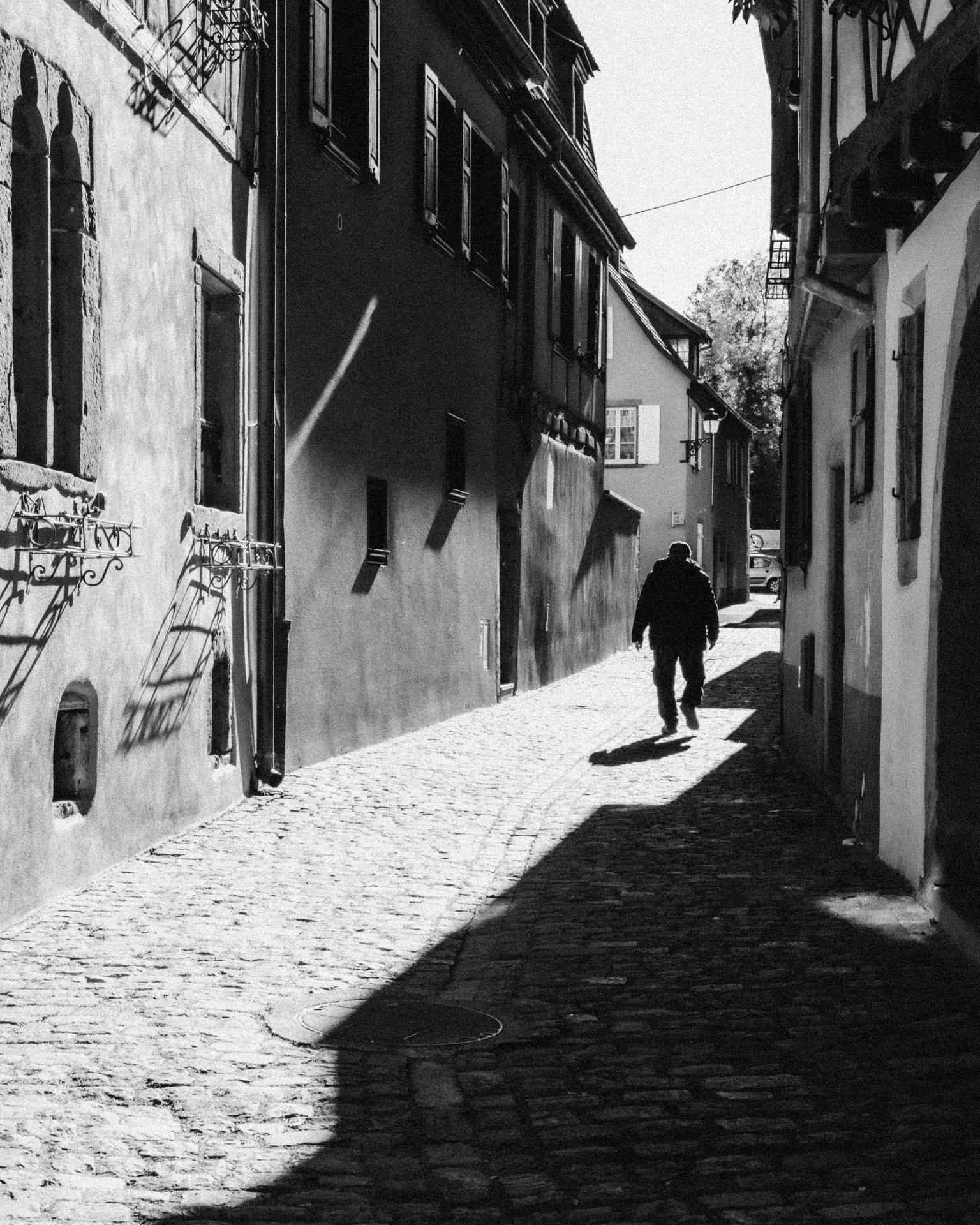 Silhouette marchant dans une ruelle en noir et blanc