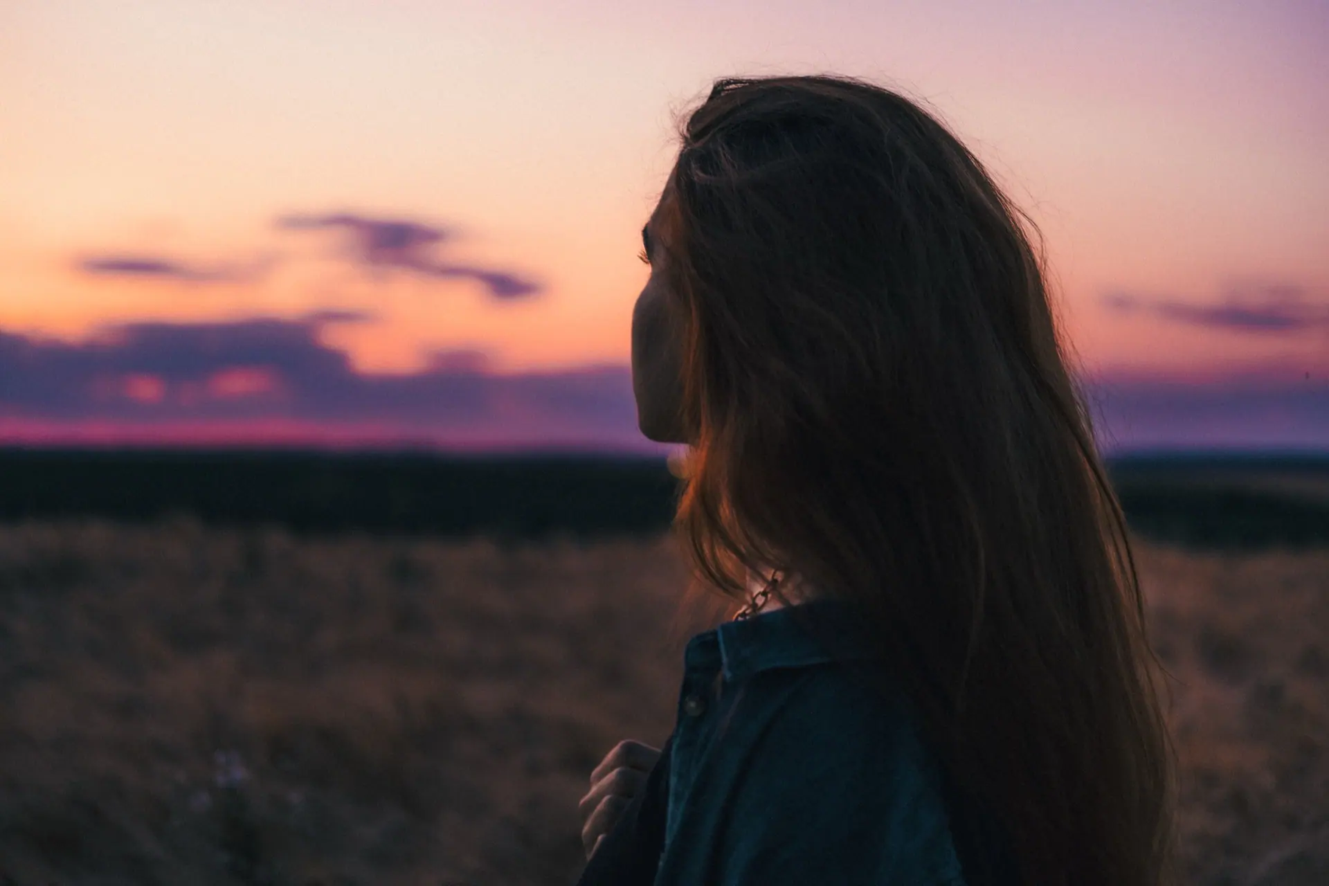 Personne de profil observant le ciel au coucher du soleil